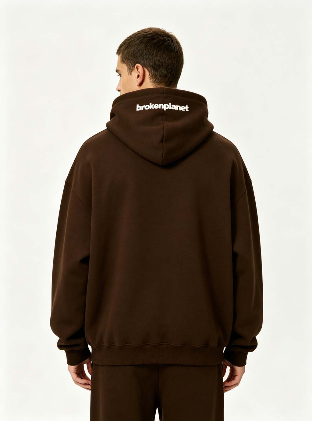 Back side profile shot of oversized pullover hoodie on male model, adjustable drawstring hood for global custom manufacturing youth casual clothing