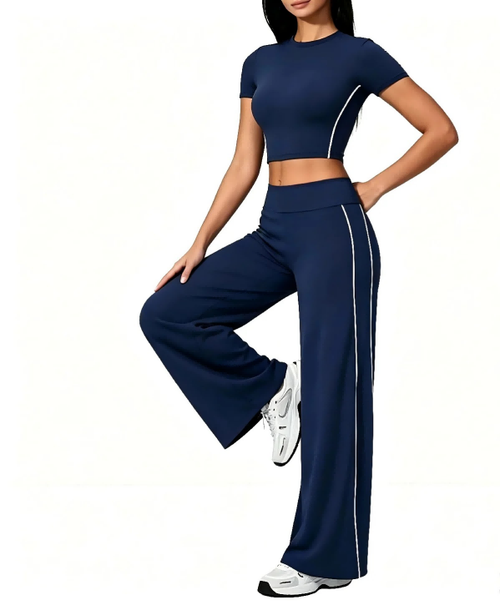 Custom Haideyu OEM ODM navy blue side striped yoga 2 piece set, nude soft stretch cropped short sleeve top, high waist wide flare leg pants, female model single leg rest pose plain white background pilates apparel