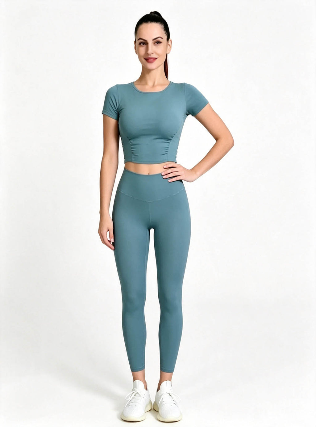 Premium Teal Short Sleeve Crop Top High‑waist Yoga Leggings Set, Female Model One‑Hand‑On‑Hip Standing Pose, Solid Color Stretchy Active‑wear Custom Outfit From Haideyu Apparel OEM ODM Service