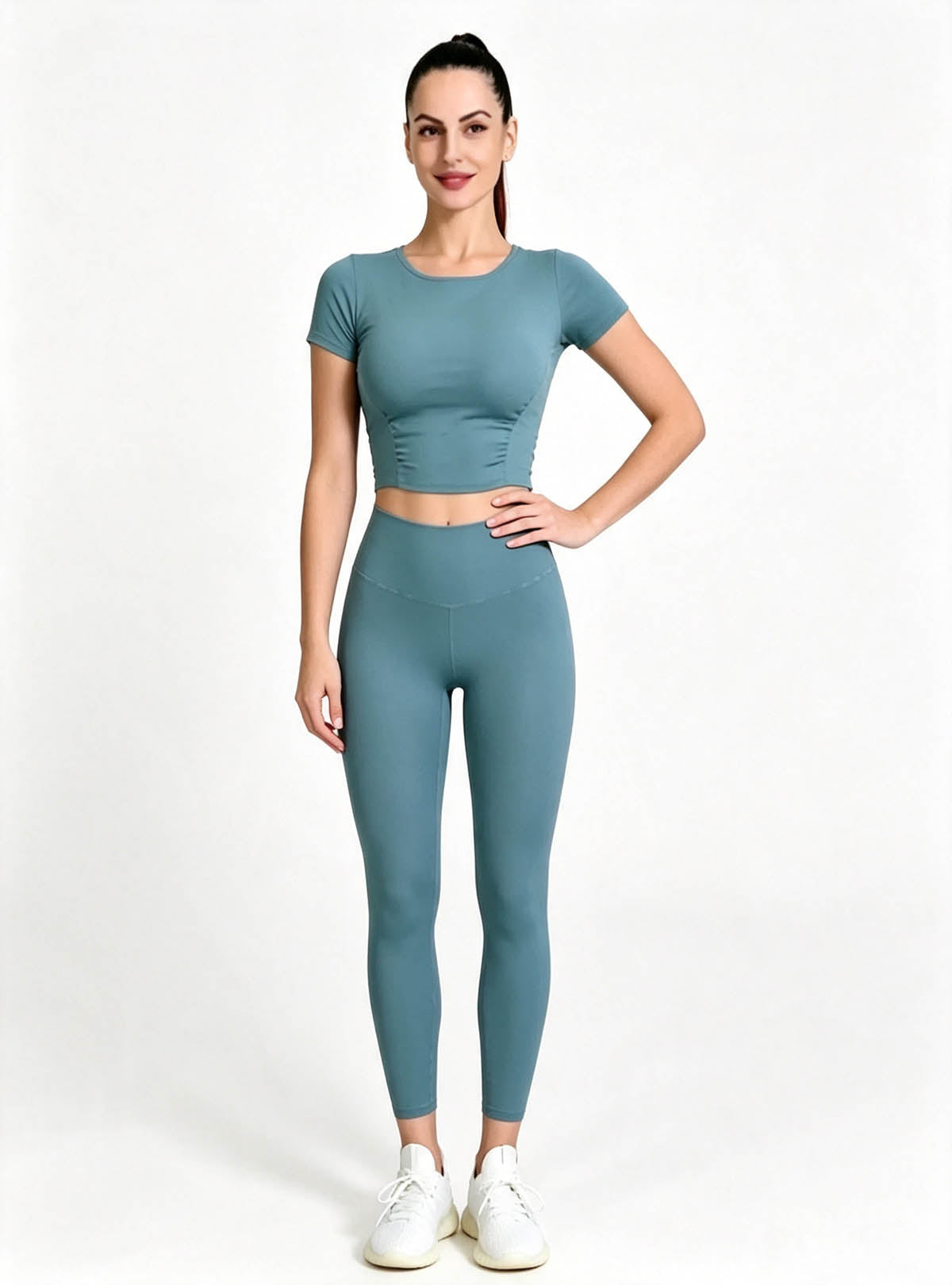 Premium Teal Short Sleeve Crop Top High‑waist Yoga Leggings Set, Female Model One‑Hand‑On‑Hip Standing Pose, Solid Color Stretchy Active‑wear Custom Outfit From Haideyu Apparel OEM ODM Service